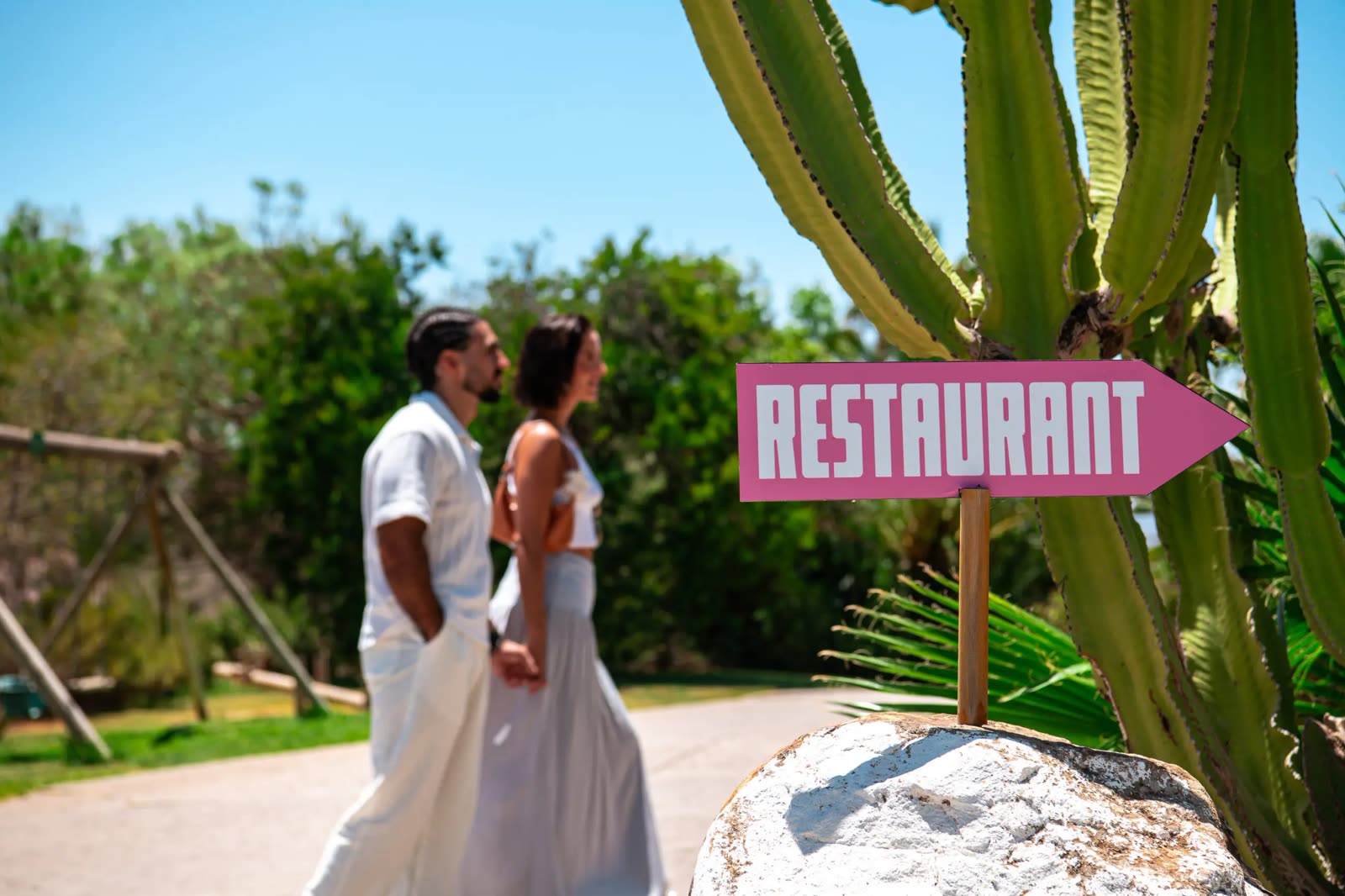 Couple walking past the restaurant signpost at Finca Cantueso